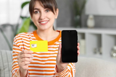 Photo of Woman with SIM card and smartphone indoors, selective focus. Space for text