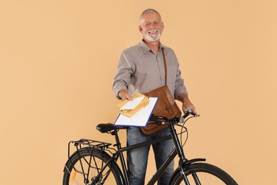 Photo of Happy postman with bicycle delivering letters on beige background
