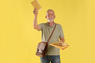 Photo of Postman with brown bag delivering letters on yellow background