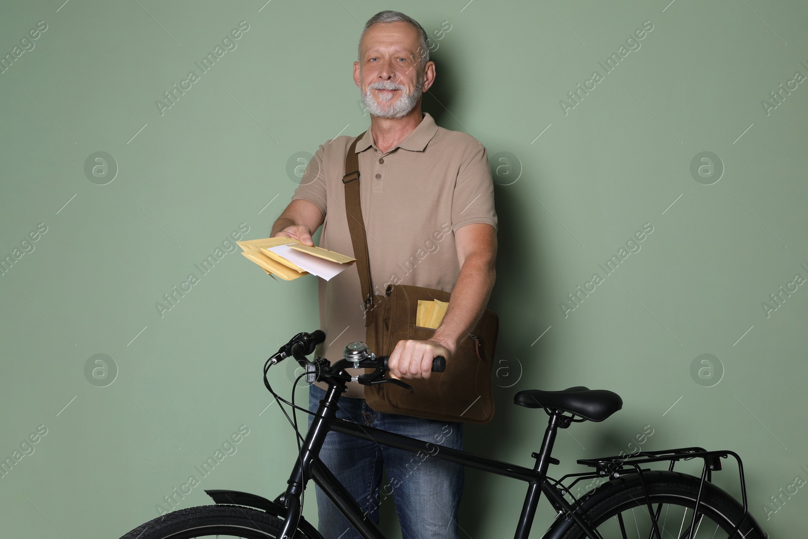 Photo of Postman with bicycle delivering letters on olive background