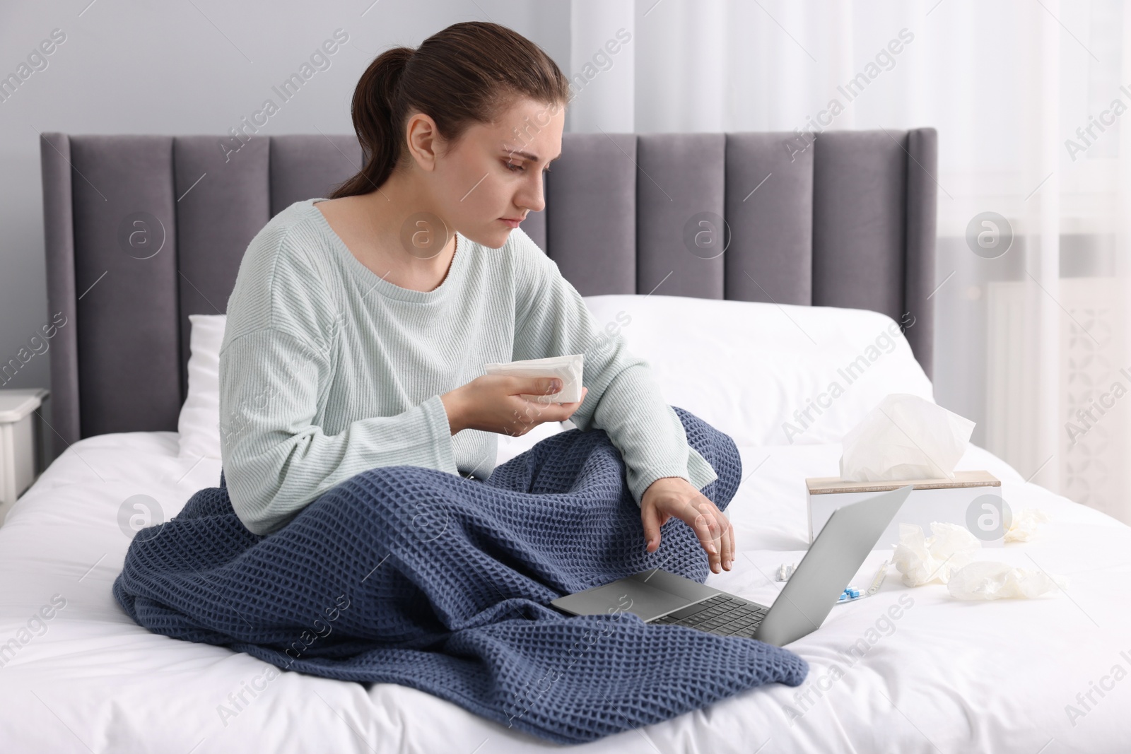 Photo of Sick woman having online consultation with doctor via laptop at home