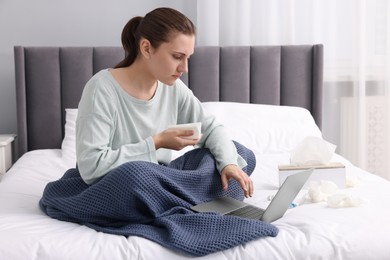 Photo of Sick woman having online consultation with doctor via laptop at home