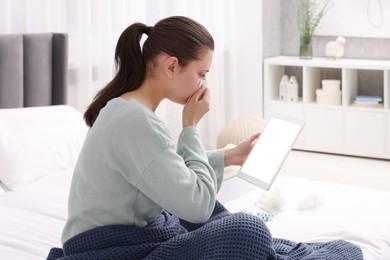 Sick woman having online consultation with doctor via tablet at home