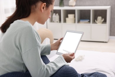 Photo of Sick woman with thermometer having online consultation with doctor via tablet at home