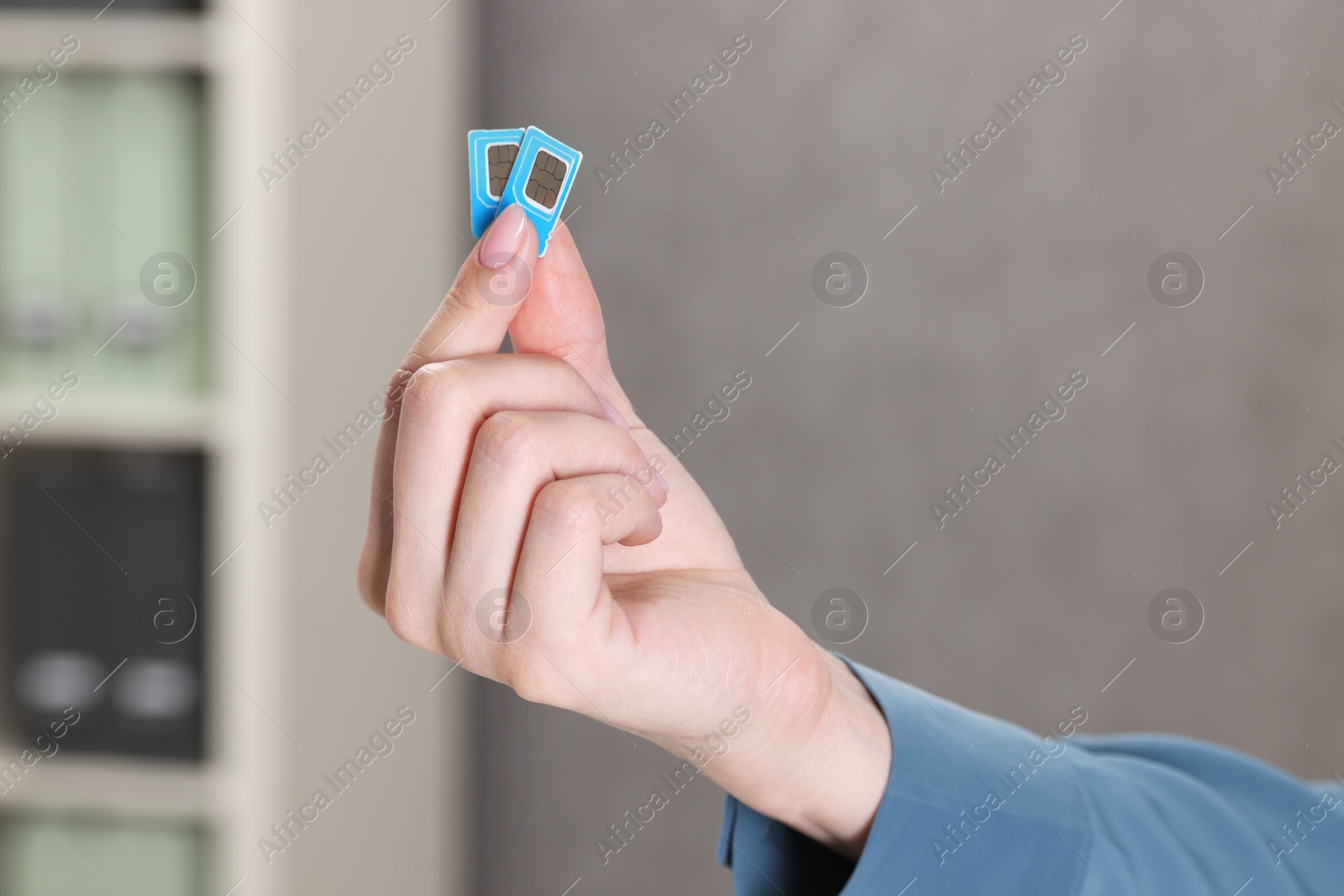 Photo of Woman holding SIM cards indoors, closeup view