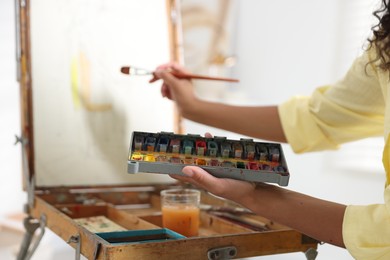 Photo of Woman drawing picture with paint in studio, closeup