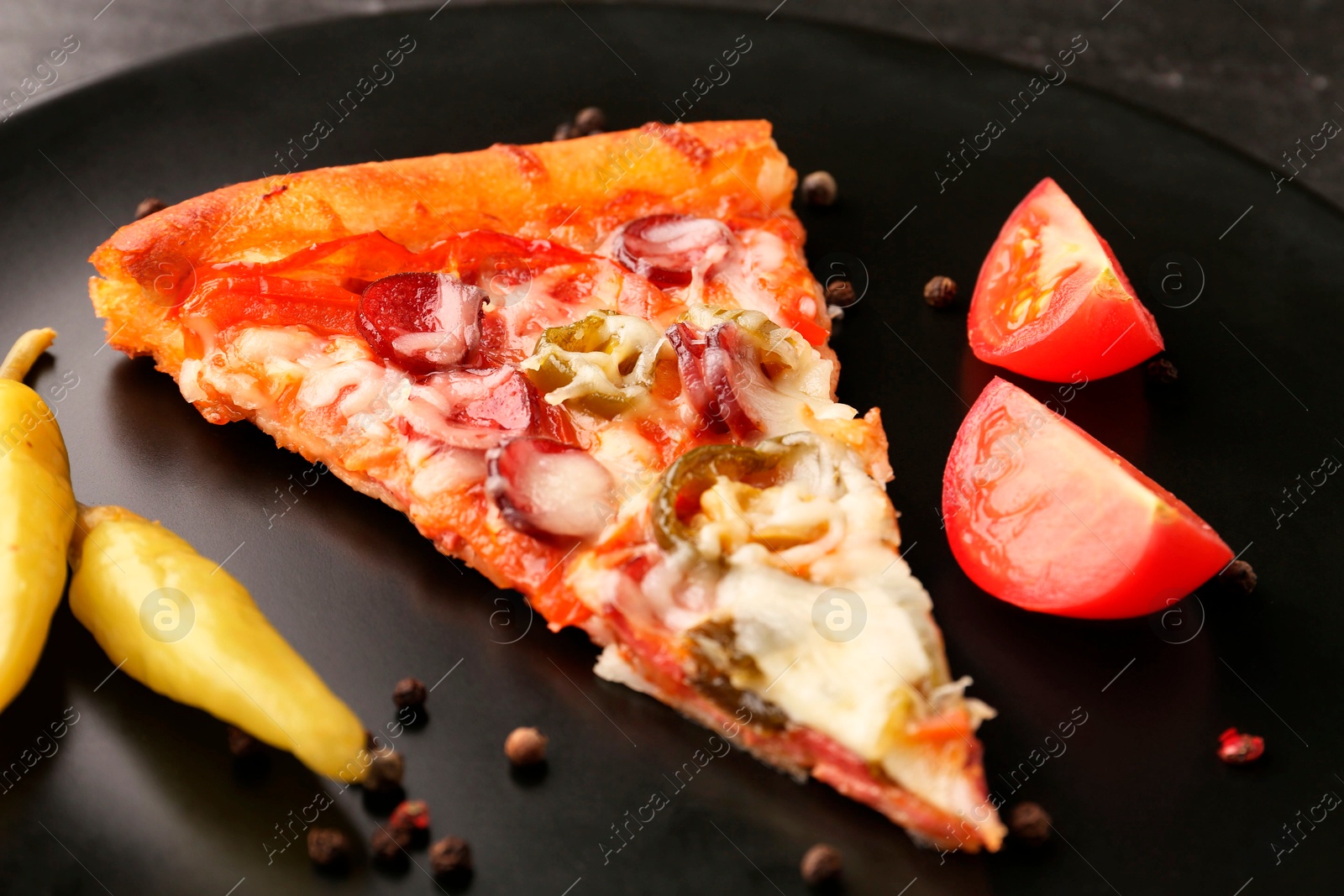 Photo of Plate with delicious pizza Diablo, pepper, tomato and peppercorns on table, closeup