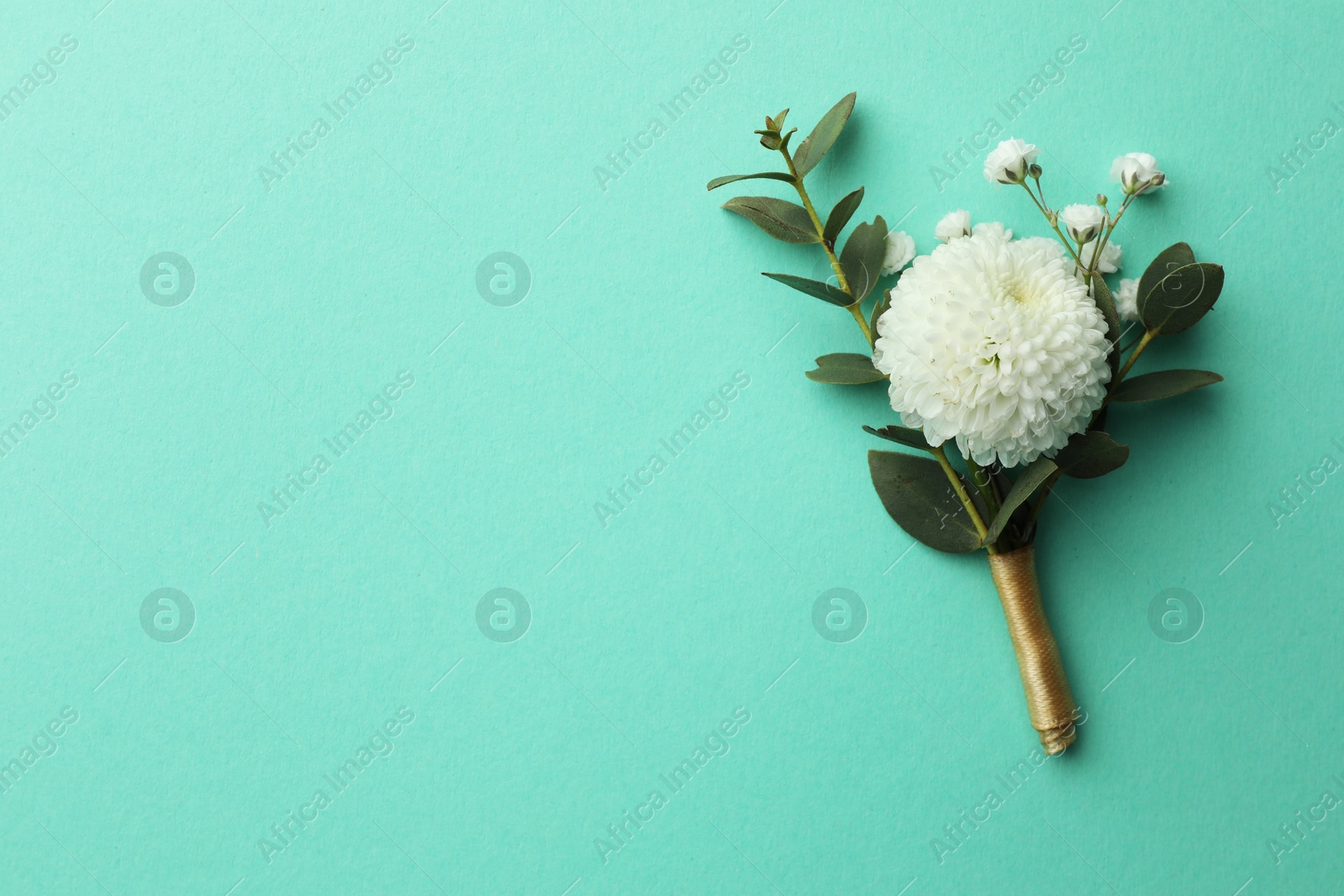 Photo of Small stylish boutonniere on turquoise background, top view. Space for text