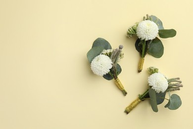 Photo of Many stylish boutonnieres on beige background, flat lay. Space for text