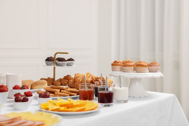 Different meals served on white table indoors. Buffet menu