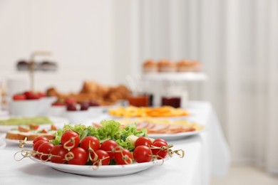 Different meals served on white table indoors, closeup. Buffet menu