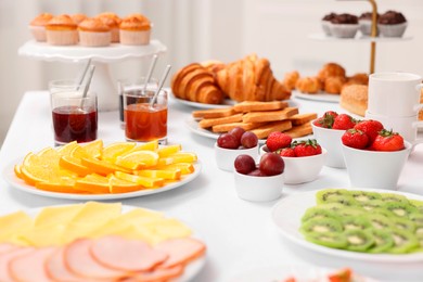 Different meals served on white table indoors, selective focus. Buffet menu