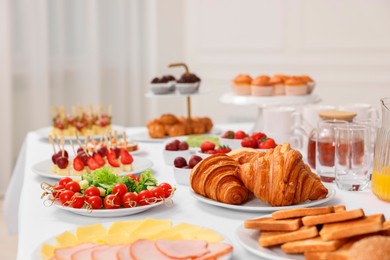 Photo of Different meals served on white table indoors. Buffet menu