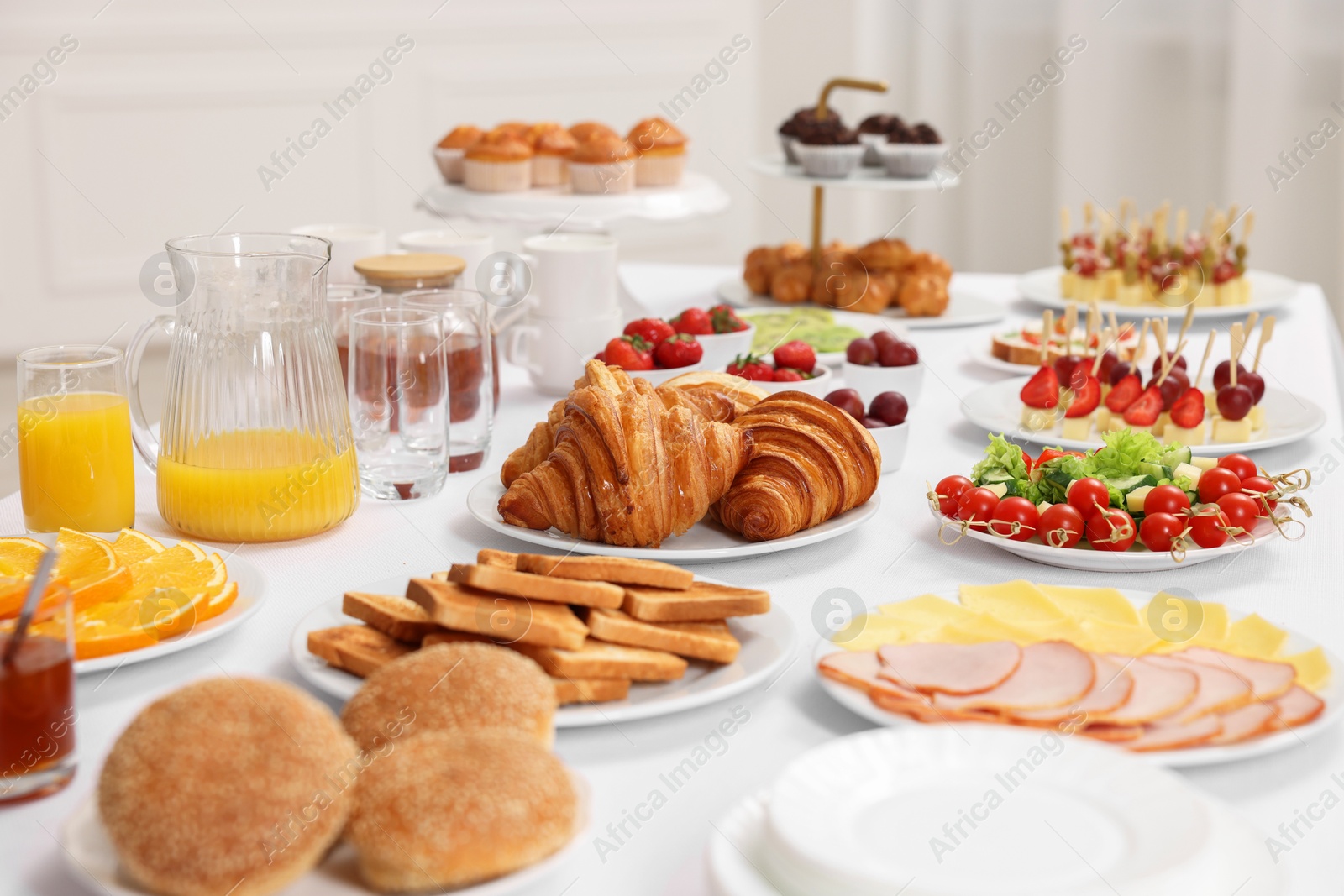 Photo of Different meals served on white table indoors. Buffet menu