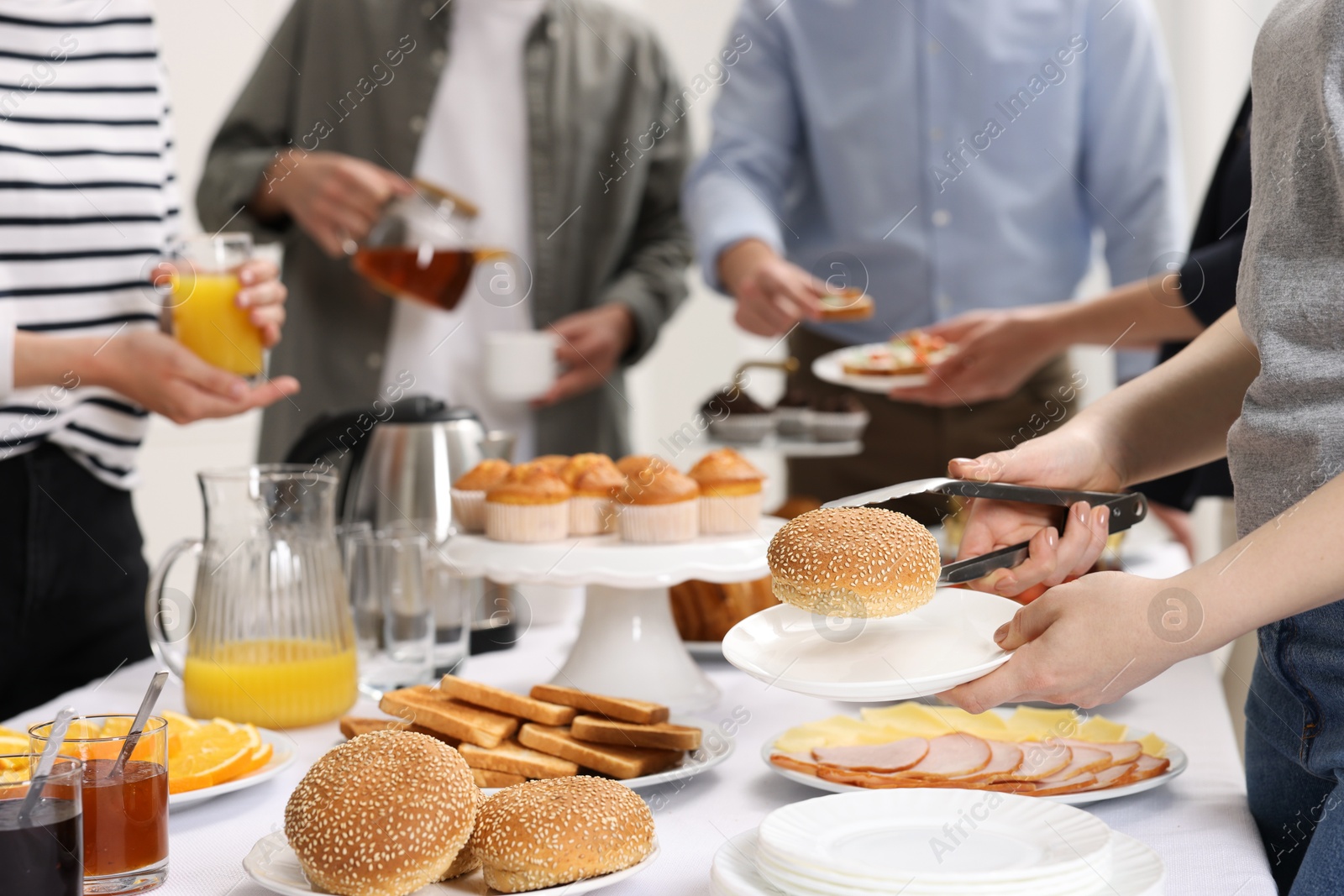 Photo of Coworkers having business lunch at white table indoors, closeup