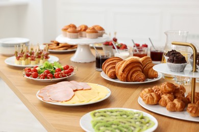 Different meals served on wooden table indoors. Buffet menu