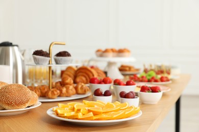 Different meals served on wooden table indoors. Buffet menu