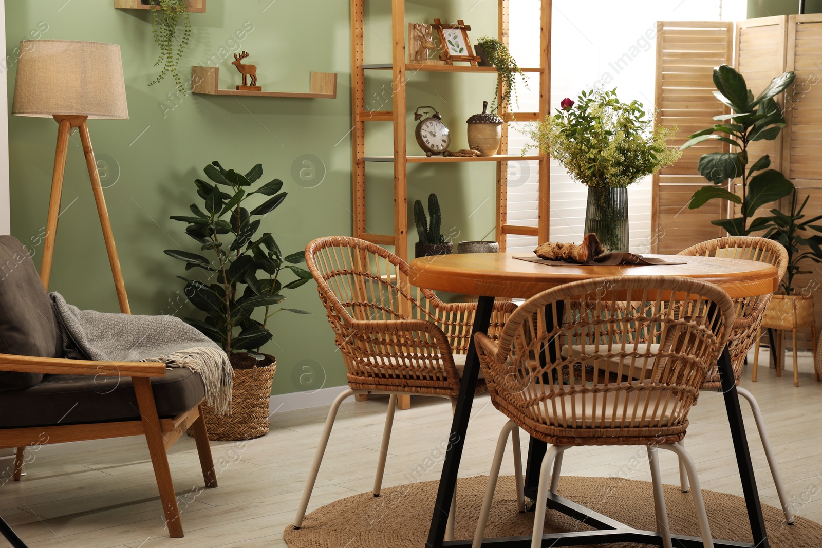 Photo of Stylish dining room interior with wooden table and rattan chairs