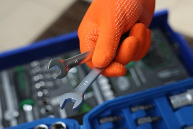 Photo of Auto mechanic with ratcheting wrenches at automobile repair shop, closeup