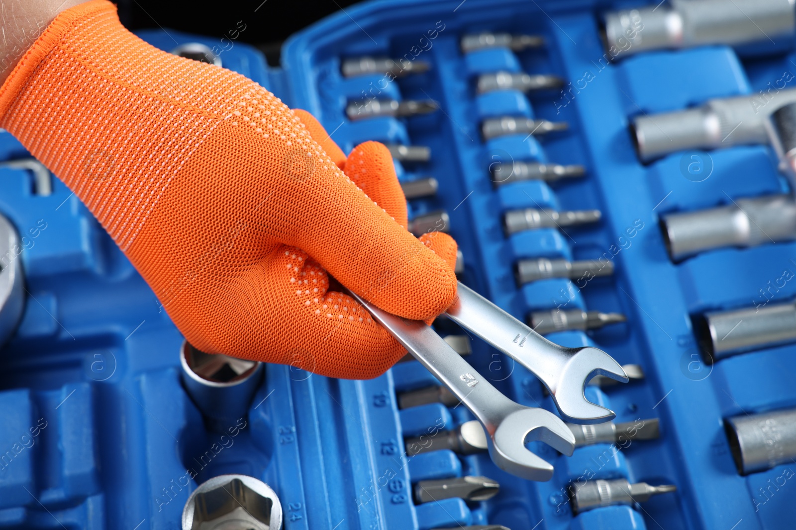 Photo of Auto mechanic with ratcheting wrenches at automobile repair shop, closeup