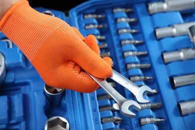 Photo of Auto mechanic with ratcheting wrenches at automobile repair shop, closeup