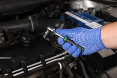 Photo of Auto mechanic with different tools at automobile repair shop, closeup