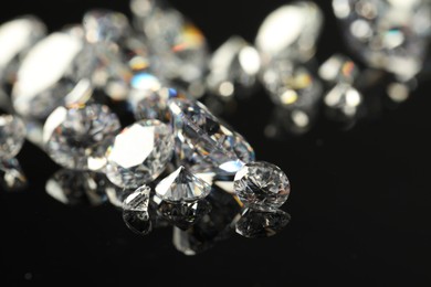 Many beautiful shiny diamonds on black mirror surface, closeup