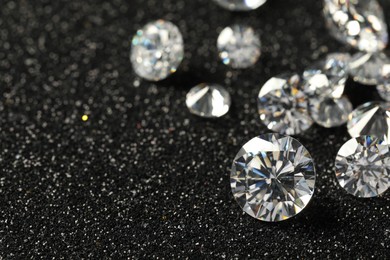 Photo of Beautiful dazzling diamonds on dark shiny background, closeup. Space for text