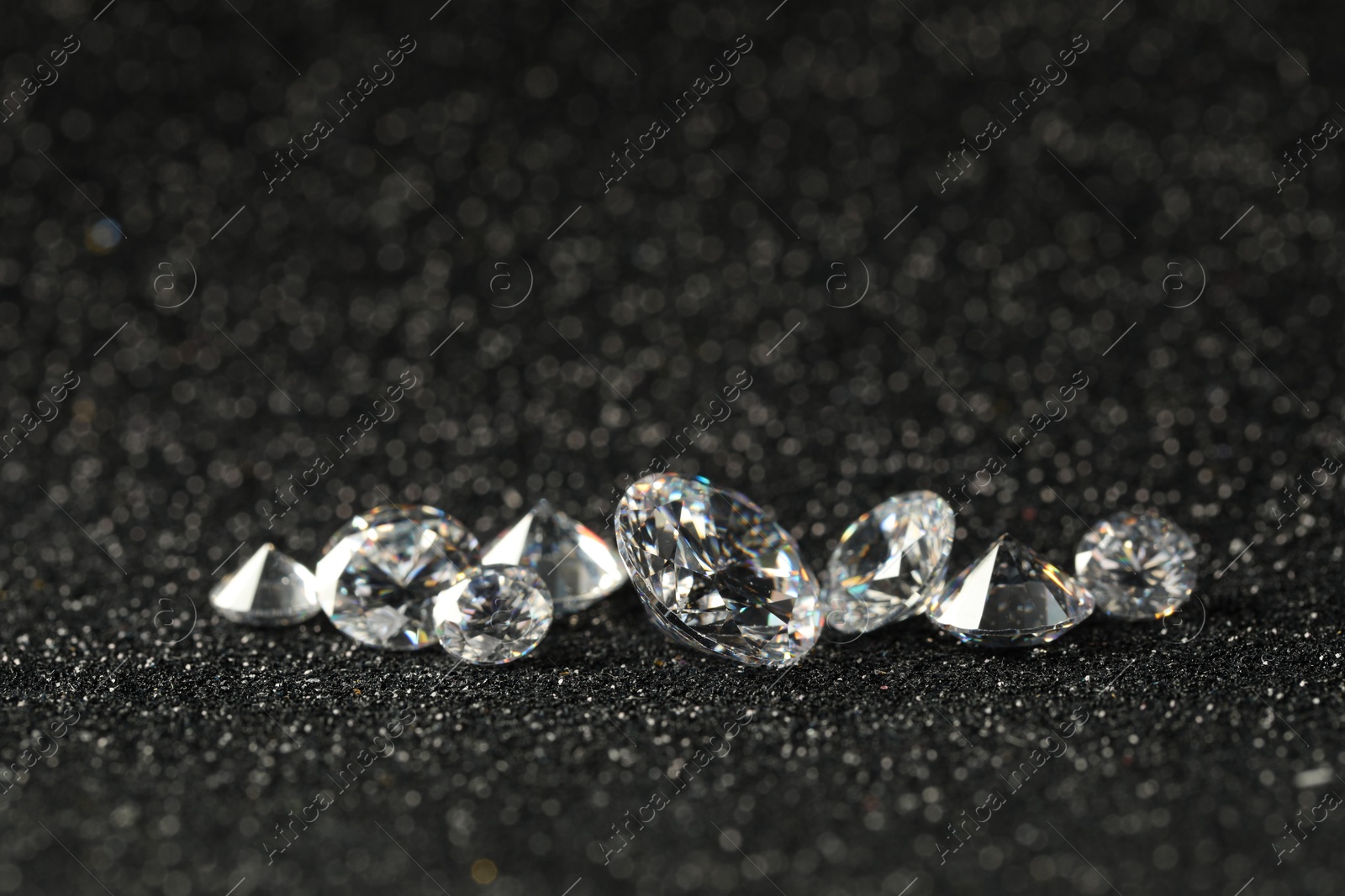 Photo of Beautiful dazzling diamonds on dark shiny background, closeup