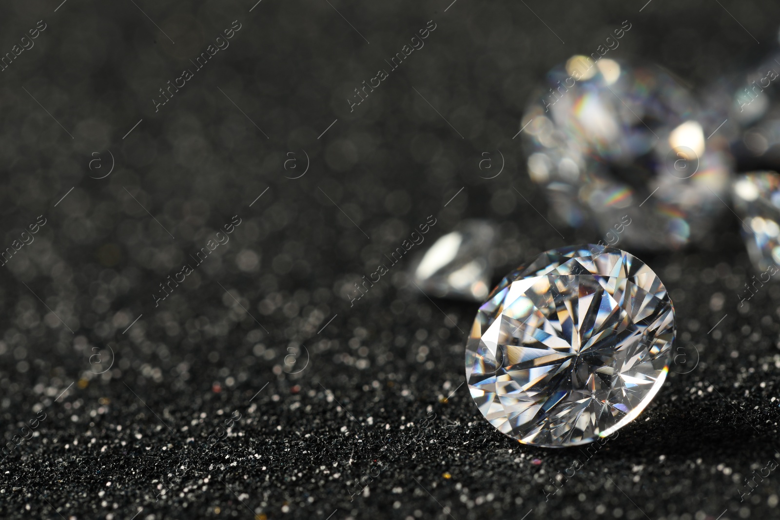 Photo of Beautiful dazzling diamonds on dark shiny background, closeup. Space for text