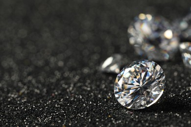 Photo of Beautiful dazzling diamonds on dark shiny background, closeup. Space for text