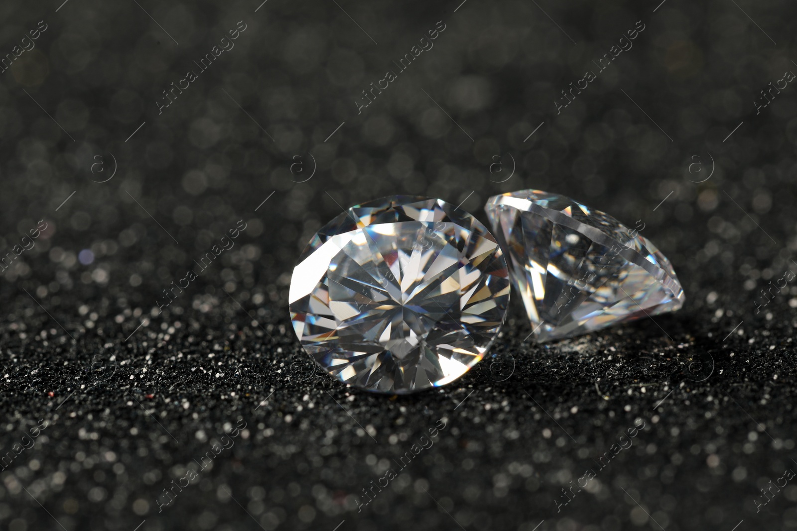 Photo of Beautiful dazzling diamonds on dark shiny background, closeup. Space for text