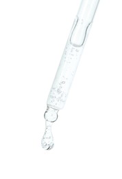 Dripping cosmetic serum from pipette on white background