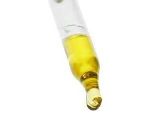 Photo of Dripping essential oil from pipette on white background