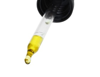 Dripping essential oil from pipette on white background