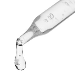 Dripping cosmetic serum from pipette on white background