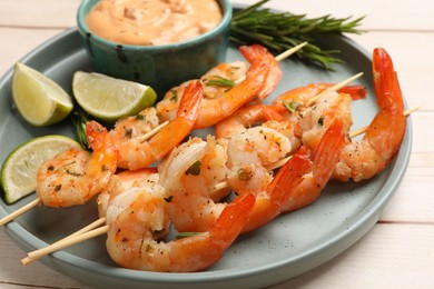 Photo of Skewers with delicious grilled shrimps served on white wooden table, closeup