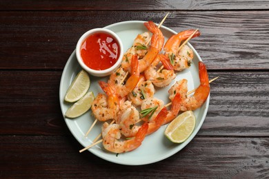 Photo of Skewers with delicious grilled shrimps served on wooden table, top view