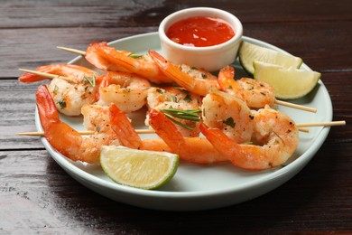 Photo of Skewers with delicious grilled shrimps served on wooden table