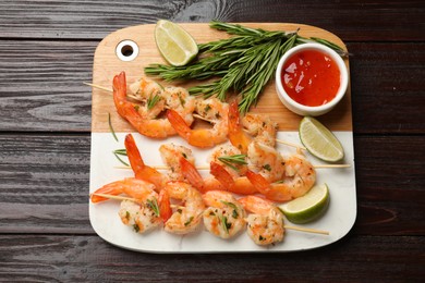 Photo of Skewers with delicious grilled shrimps served on wooden table, top view