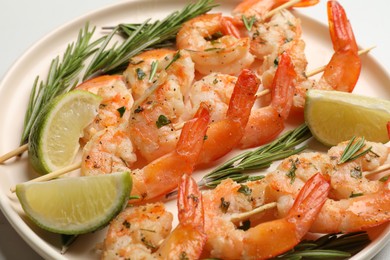 Photo of Skewers with delicious grilled shrimps served on plate, closeup