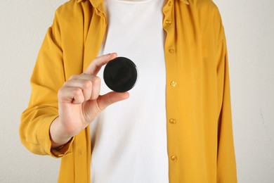 Photo of Woman with blank black button badge on light background, closeup