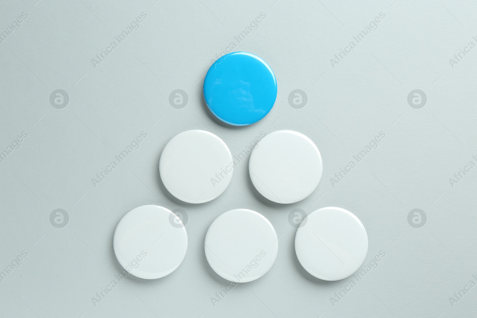 Photo of Blank button badges on light background, flat lay. Mockup for design