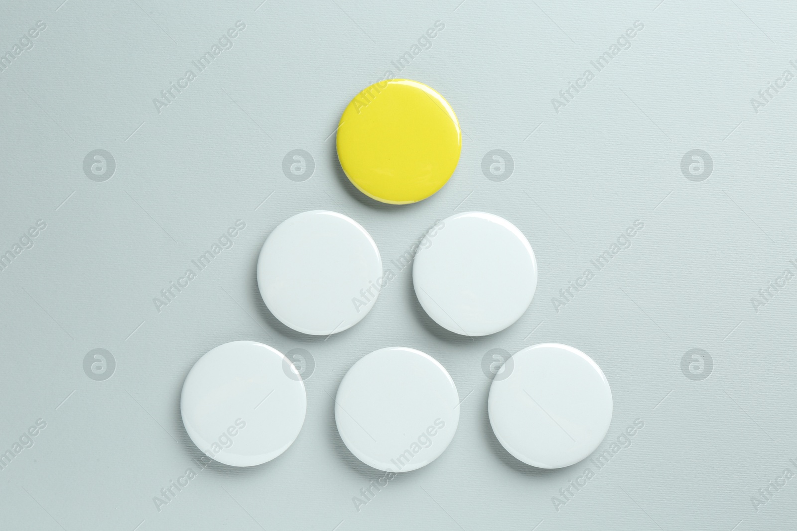 Photo of Blank button badges on light background, flat lay. Mockup for design