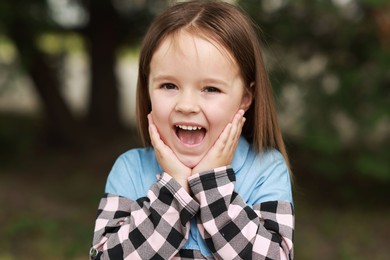 Photo of Portrait of emotional little girl outdoors. Cute child