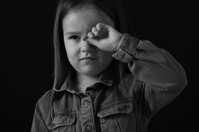 Portrait of sad girl on dark background, closeup. Black and white effect