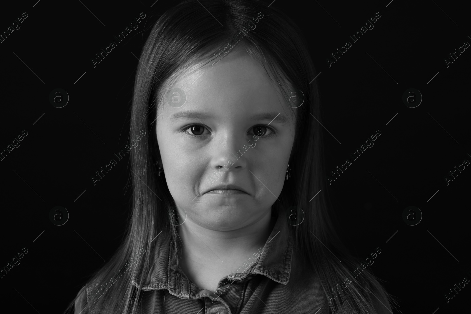 Photo of Portrait of sad girl on dark background, closeup. Black and white effect