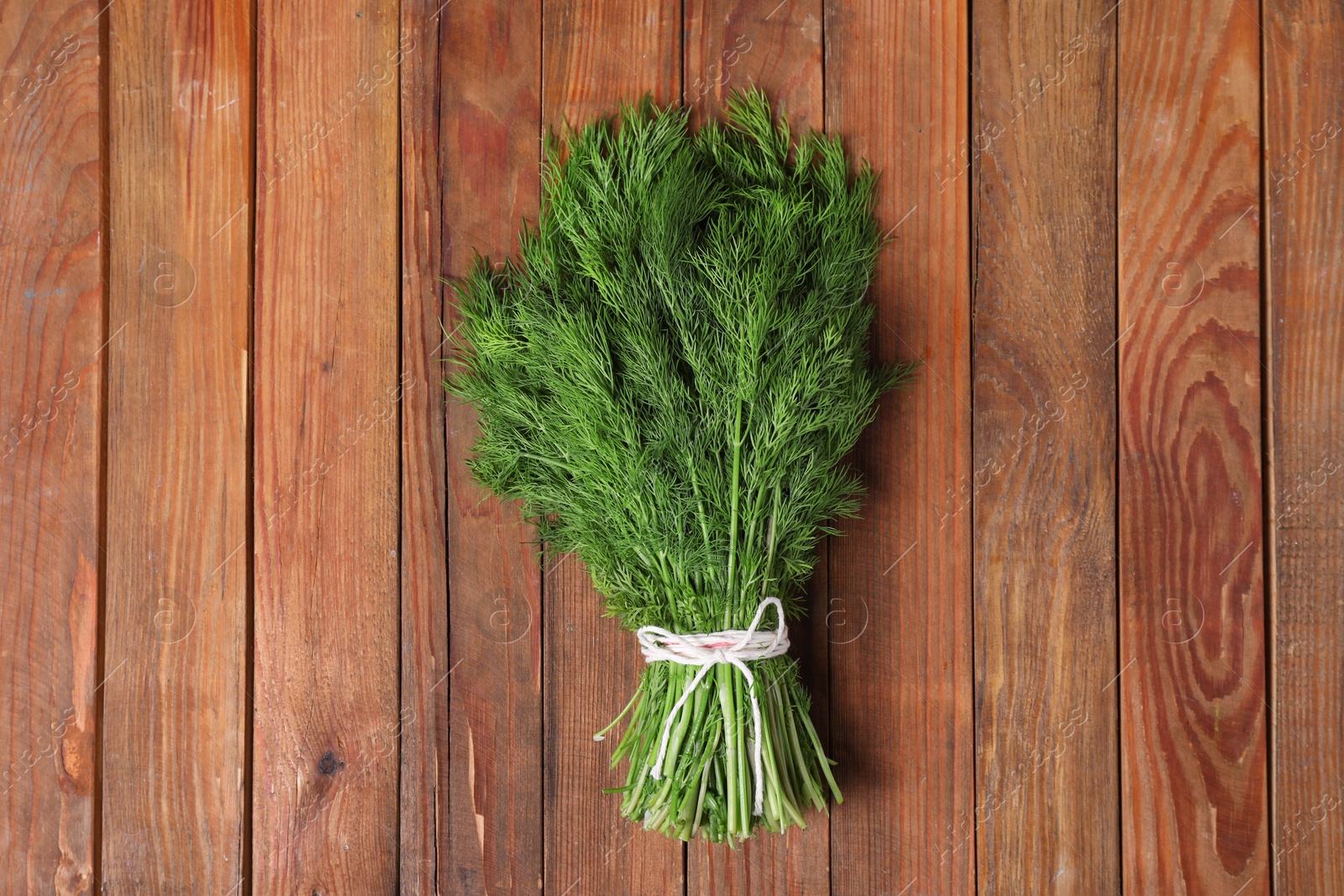 Photo of Bunch of fresh green dill on wooden table, top view