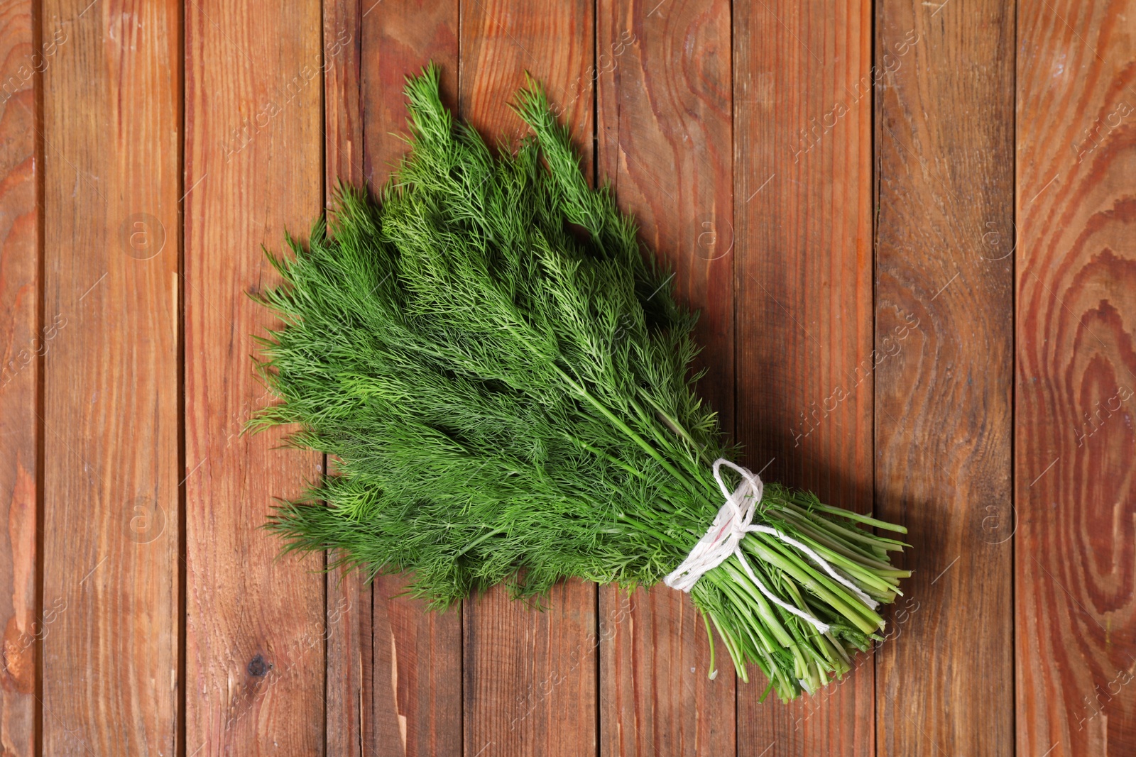 Photo of Bunch of fresh green dill on wooden table, top view