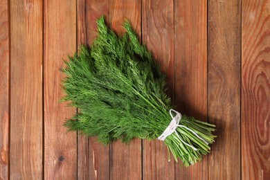 Photo of Bunch of fresh green dill on wooden table, top view